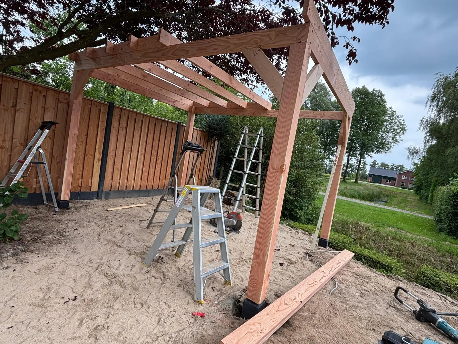 Bouwproces van een houten overkapping met zichtbaar frame