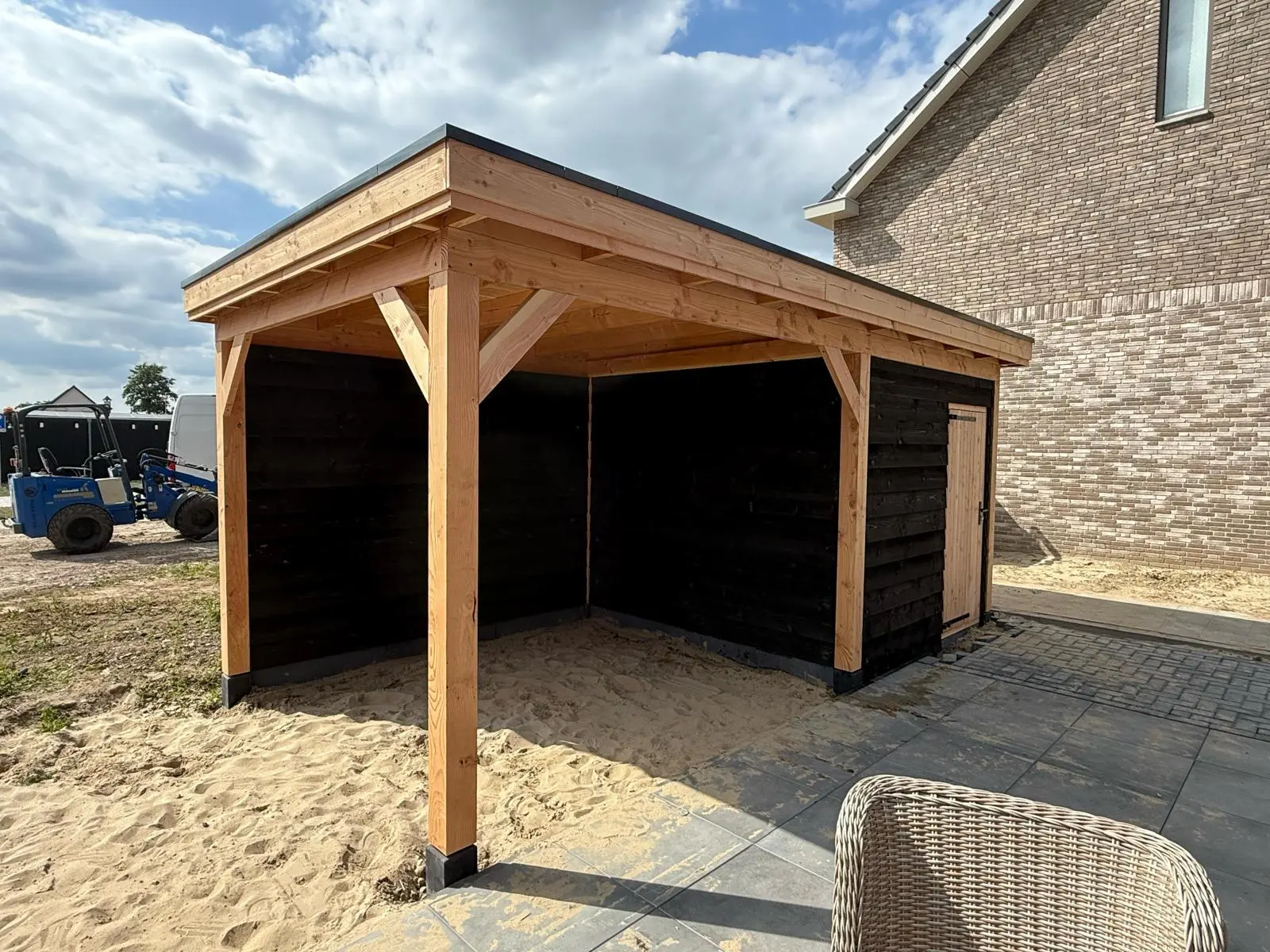 Houten overkapping met berging naast een woning