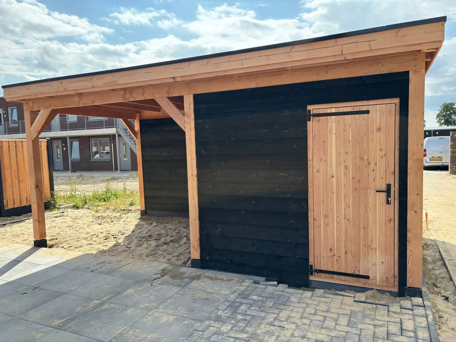 Houten overkapping met berging in een nieuwbouwwijk