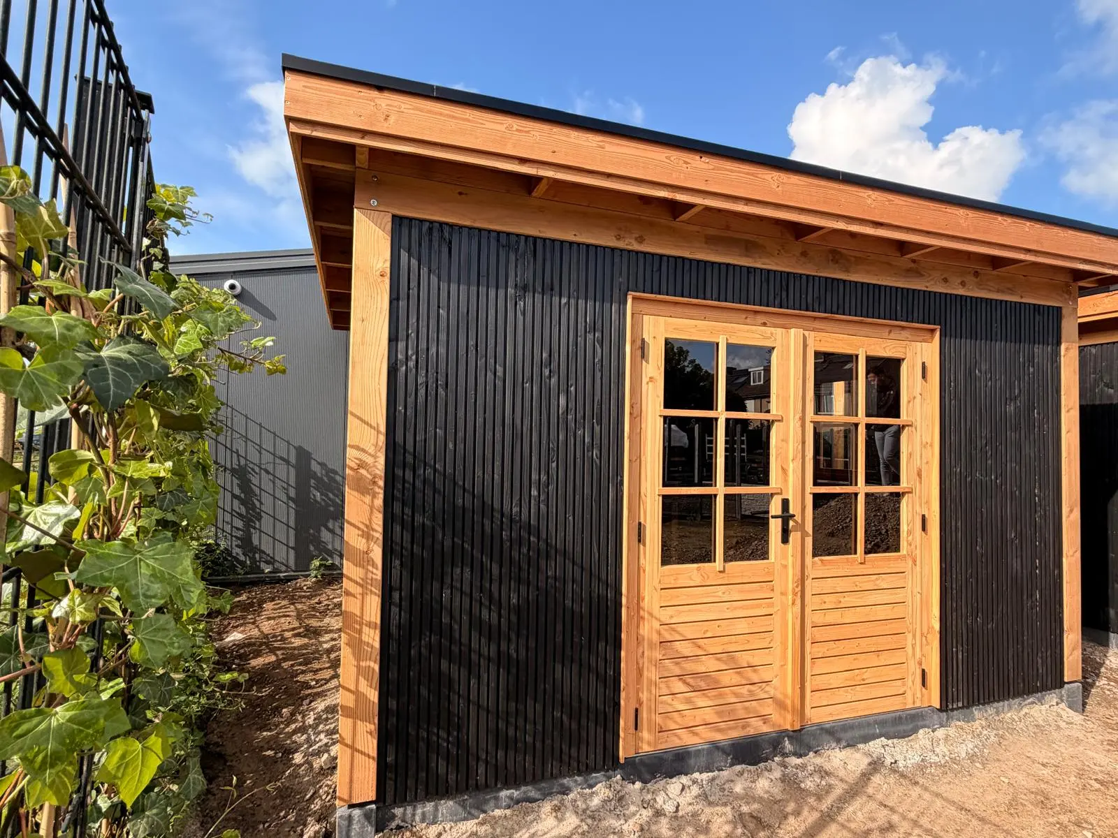 Zwart tuinhuis met douglas glasdeuren
